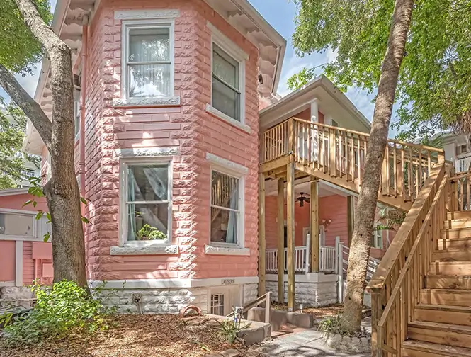 stairs leading up to the second floor of a pink building